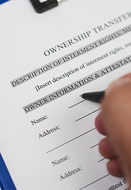 Image of a hand signing a living trust document